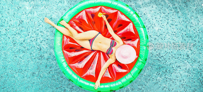 年轻的女人放松在酒店度假池西瓜lilo -顶视图富有的女孩浮动与水果床垫喝鸡尾酒-夏季假日概念-关注她的身体-软饱和过滤器